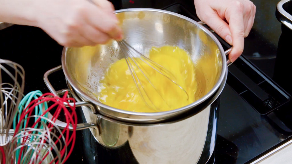 Crema di uova per la carbonara lavorata a bagnomaria con una frusta a mano