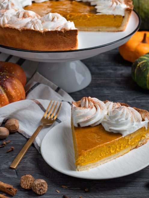 Pumpkin pie con ripieno di zucca e ciuffi di panna montata spolverati di cannella