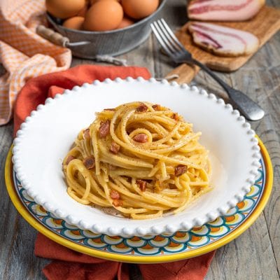 Spaghetti alla carbonara con guanciale croccante e pepe nero, arrotolati a nido