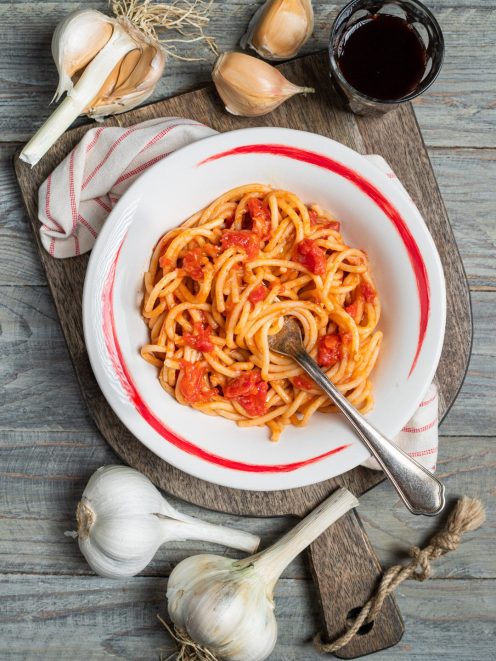 Pici all'aglione conditi con sugo di pomodoro a pezzi, serviti con forchetta