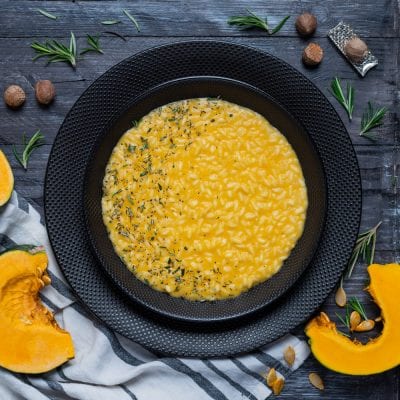 Risotto alla zucca cremoso e all'onda, guarnito con rosmarino tritato