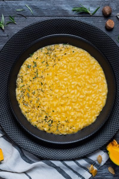 Risotto alla zucca cremoso e all'onda, guarnito con rosmarino tritato
