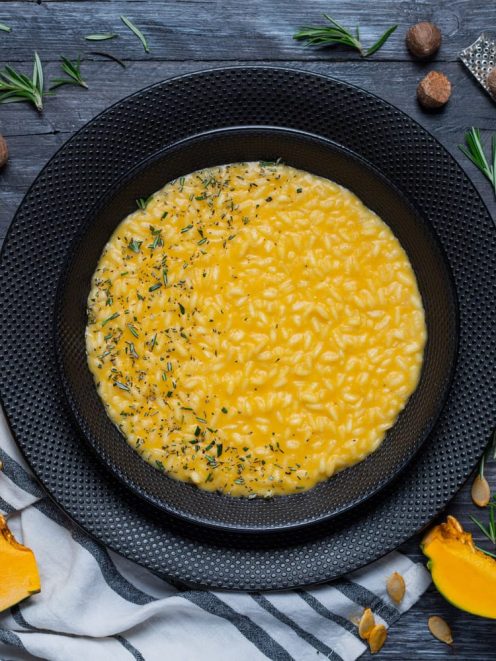 Risotto alla zucca cremoso e all'onda, guarnito con rosmarino tritato