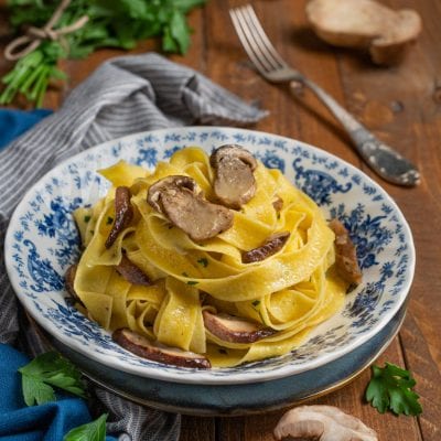 Tagliatelle ai funghi porcini all'uovo con fette di porcini saltati e prezzemolo tritato