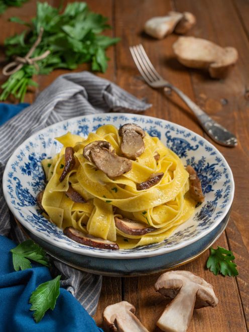 Tagliatelle ai funghi porcini all'uovo con fette di porcini saltati e prezzemolo tritato
