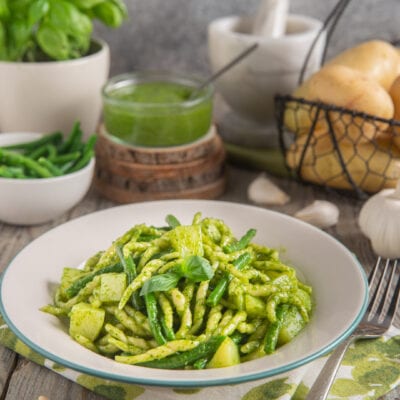 Trofie al pesto con patate e fagiolini condite con pesto genovese fresco e foglie di basilico
