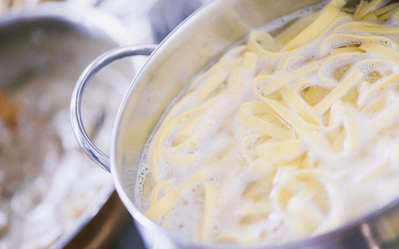 Tagliatelle fresche in ebollizione nell'acqua schiumosa durante la cottura