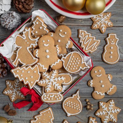Biscotti pan di zenzero natalizi decorati con glassa bianca in forme di omini, alberi e fiocchi di neve