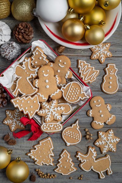 Biscotti pan di zenzero natalizi decorati con glassa bianca in forme di omini, alberi e fiocchi di neve