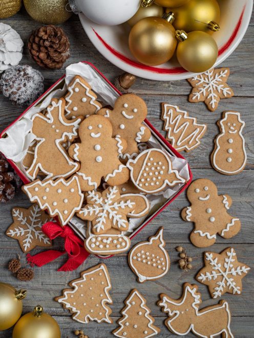 Biscotti pan di zenzero natalizi decorati con glassa bianca in forme di omini, alberi e fiocchi di neve