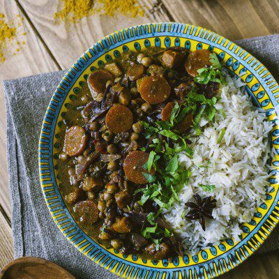 Curry di verdure con carote, ceci e cipolla rossa, servito con riso pilaf e coriandolo fresco
