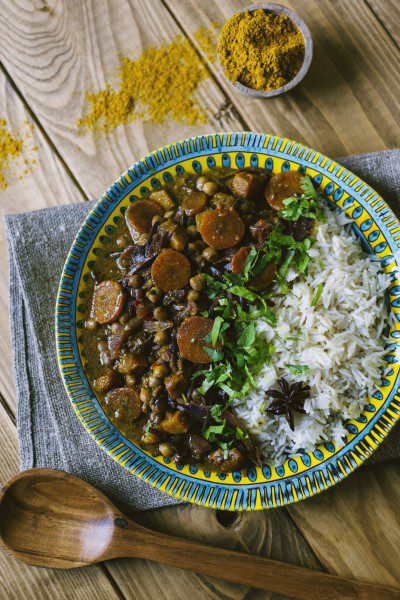 Curry di verdure con carote, ceci e cipolla rossa, servito con riso pilaf e coriandolo fresco