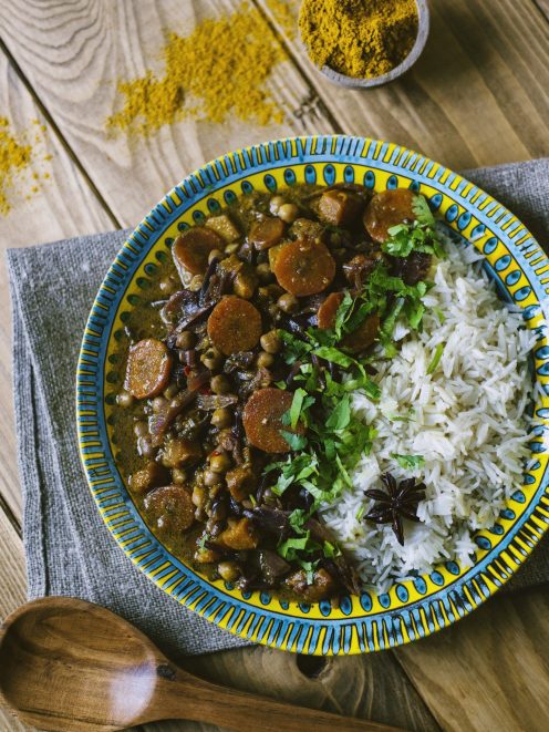 Curry di verdure con carote, ceci e cipolla rossa, servito con riso pilaf e coriandolo fresco