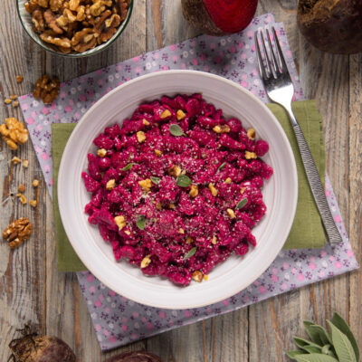Spätzle alla barbabietola conditi con noci tritate, salvia e formaggio grattugiato