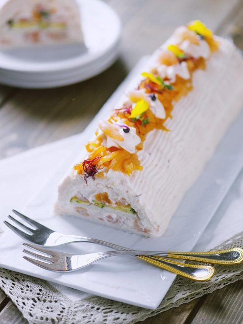 Tronchetto salato farcito con crema, frutta candita e petali di fiori eduli sulla sommità