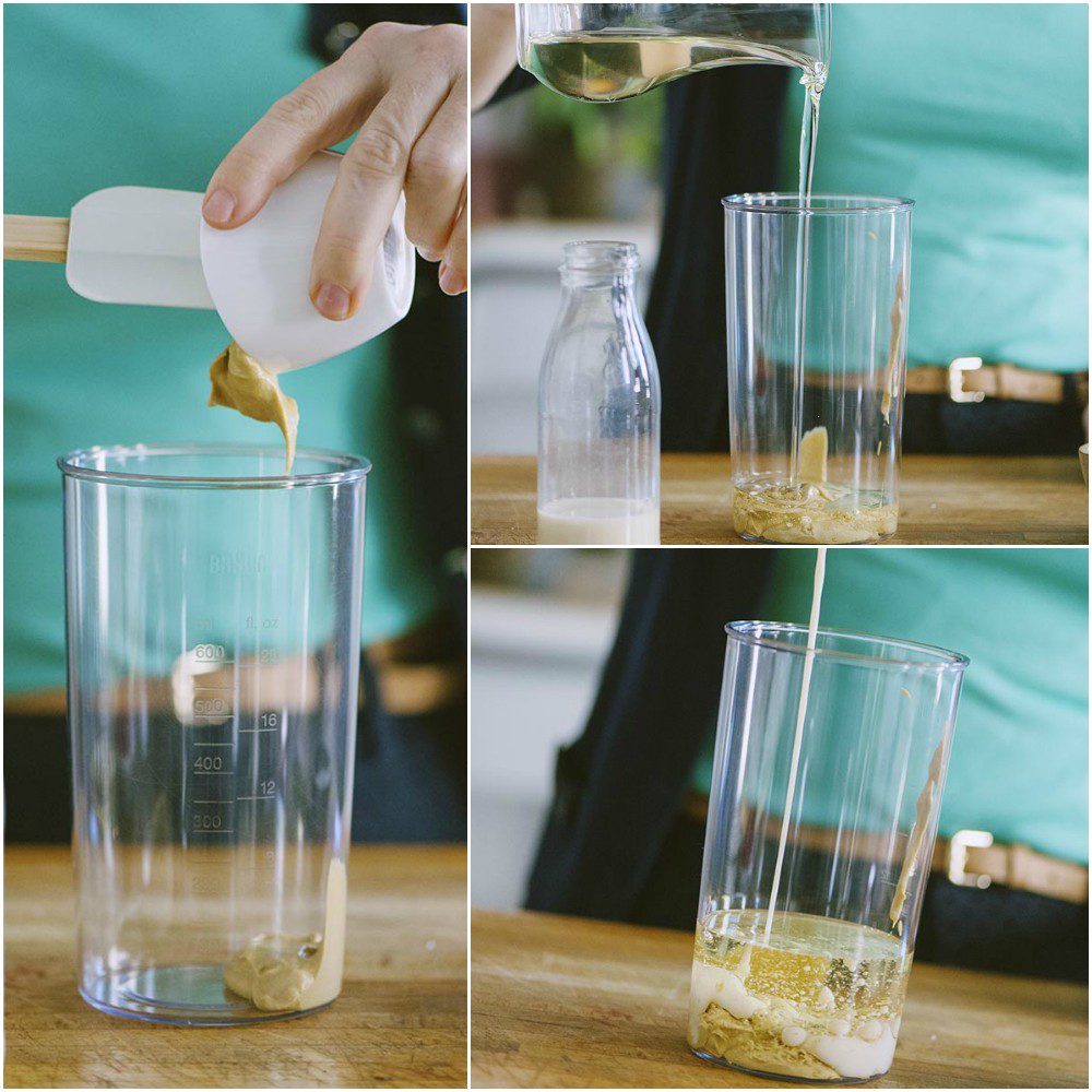 Senape, olio e latte di soia versati nel bicchiere del frullatore a immersione