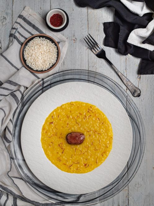 Risotto alla milanese con pistilli di zafferano e midollo al centro, servito all'onda