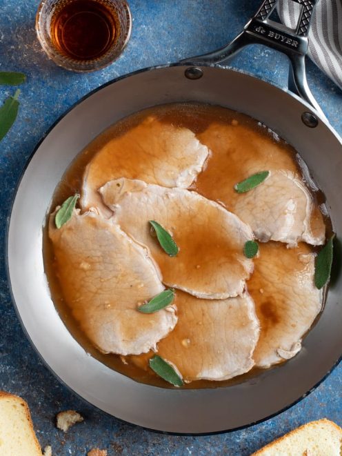 Scaloppine al marsala in padella con foglie di salvia e fondo di cottura lucido