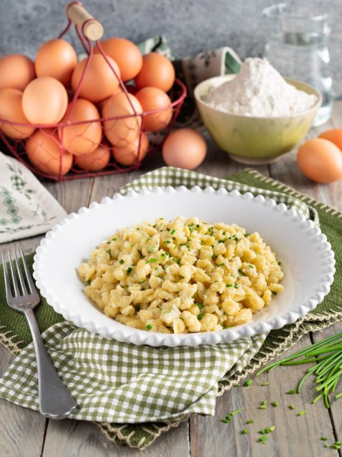 Spätzle conditi con burro e guarniti con erba cipollina fresca tritata