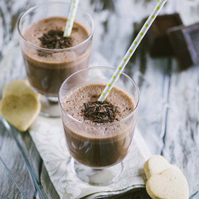 Milkshake al cioccolato con scaglie di fondente e cannuccia a pois, servito in due bicchieri