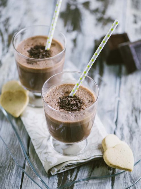 Milkshake al cioccolato con scaglie di fondente e cannuccia a pois, servito in due bicchieri