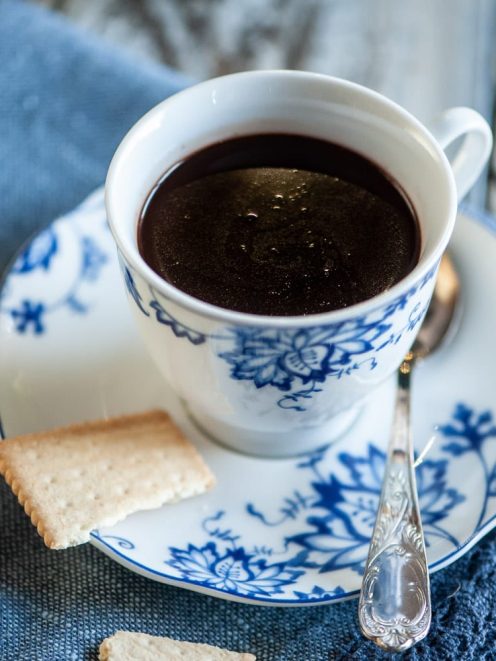 Cioccolata calda in tazza servita con biscotti secchi al lato