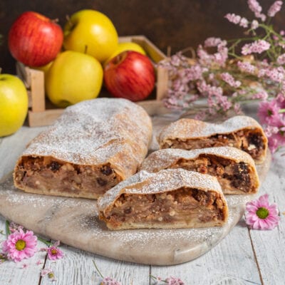 Strudel di mele affettato con ripieno di mele, uvetta e noci, spolverato di zucchero a velo