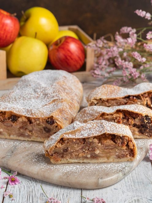 Strudel di mele affettato con ripieno di mele, uvetta e noci, spolverato di zucchero a velo