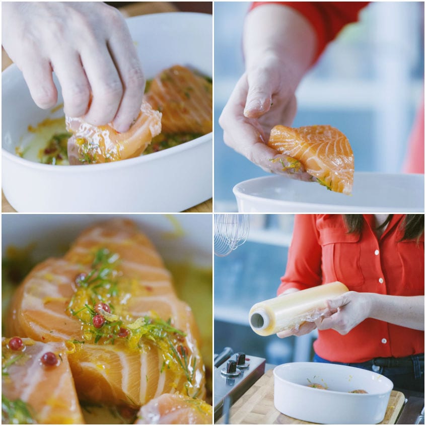Cuori di salmone immersi nella marinatura con finocchietto e bacche rosa, poi coperti con pellicola