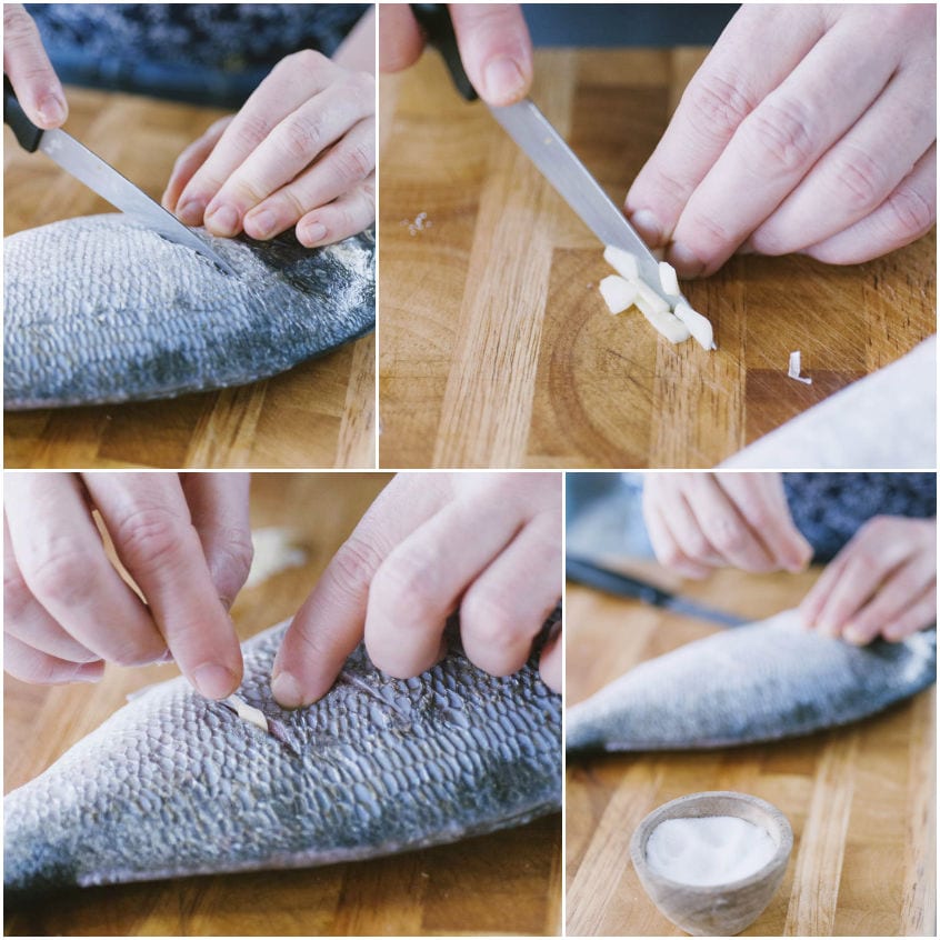 Incisioni sul dorso dell'orata, fettine di aglio inserite nelle fessure e salatura del pesce