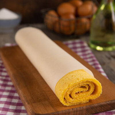 Pasta biscotto all'olio arrotolata con carta forno, pronta per essere farcita