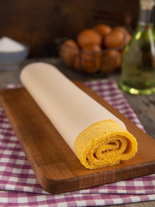 Pasta biscotto all'olio arrotolata con carta forno, pronta per essere farcita