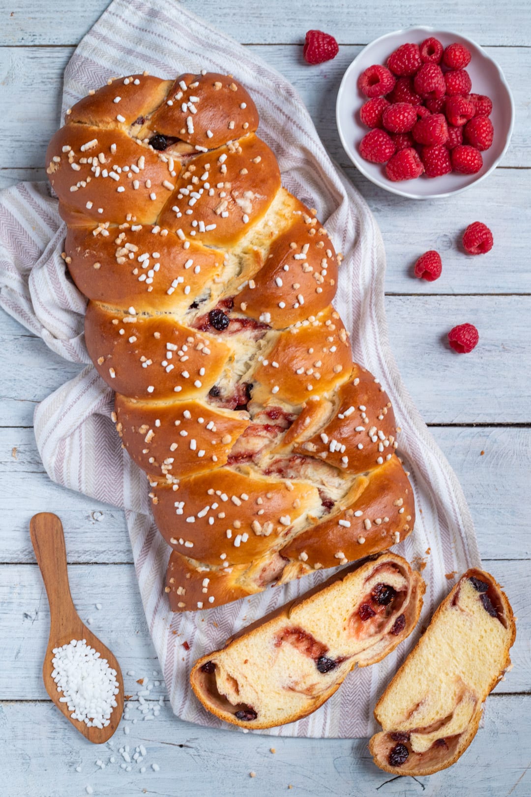 Treccia ai frutti rossi affettata con il ripieno di lamponi e frutti di bosco ben visibile