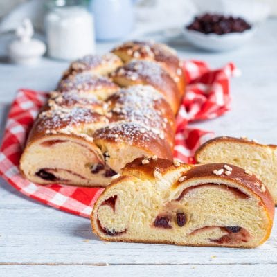Treccia ai frutti rossi affettata con ripieno di uvetta e confettura, granella di zucchero in superficie