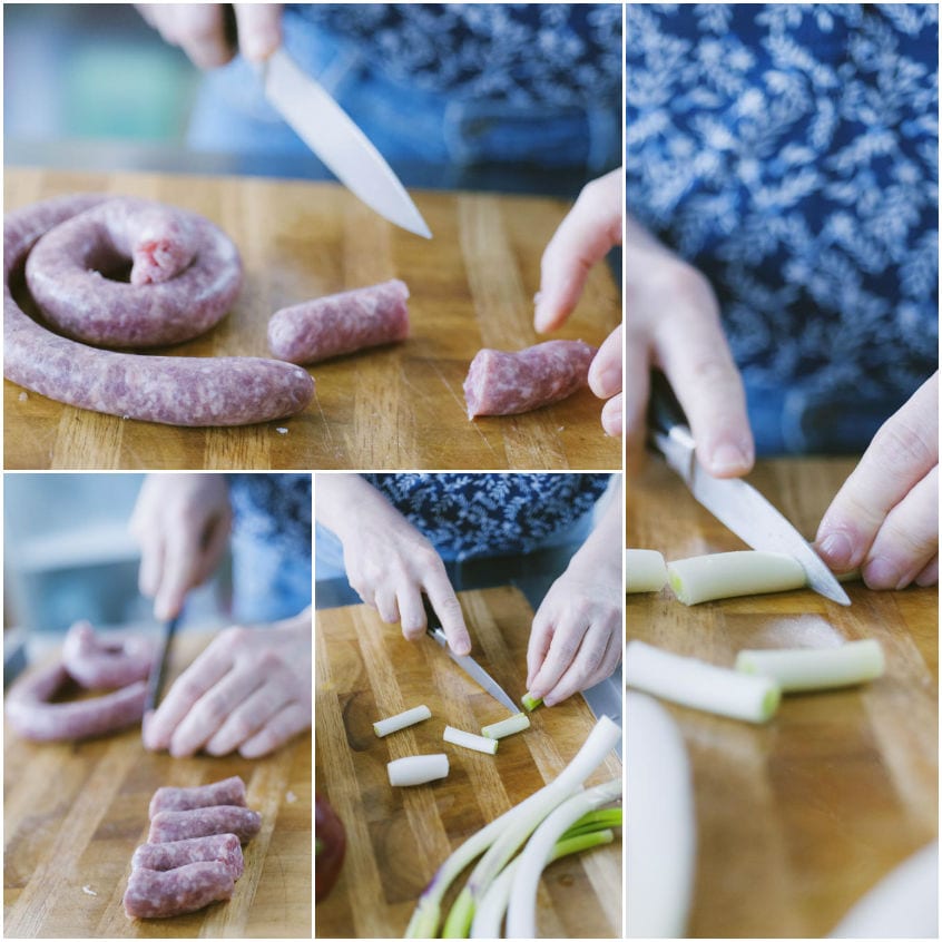 Salsiccia a spirale tagliata a tocchetti e cipollotti affettati sul tagliere