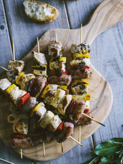 Spiedini di carne con bocconcini di pollo, salsiccia e peperoni grigliati conditi con erbe aromatiche