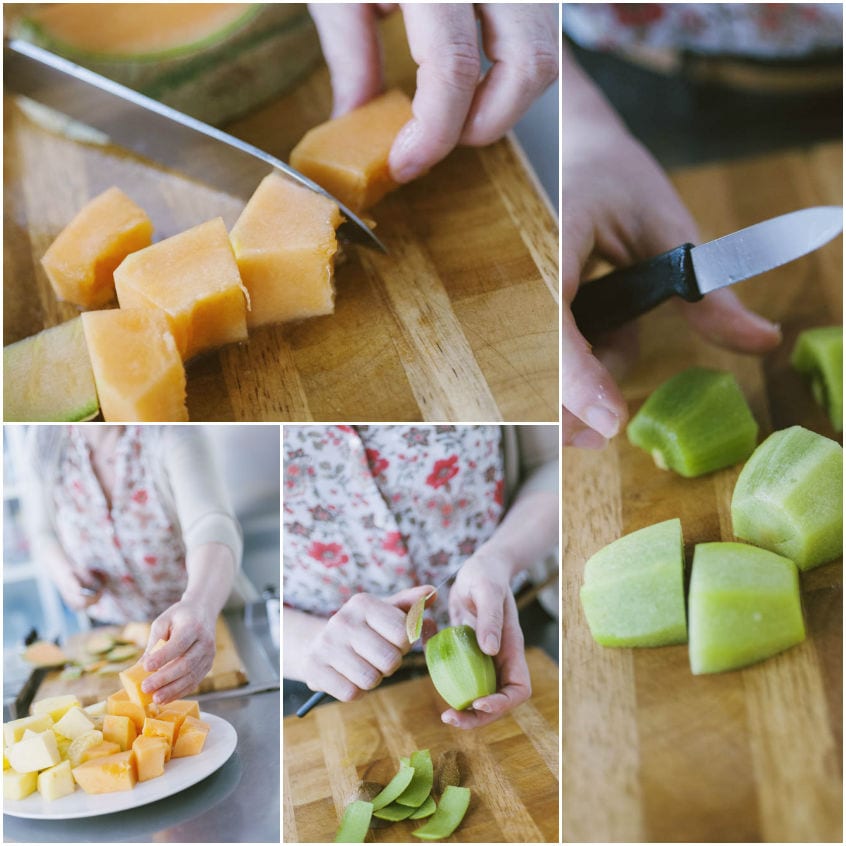 Melone arancione e kiwi tagliati a cubetti sul tagliere, pronti per gli spiedini