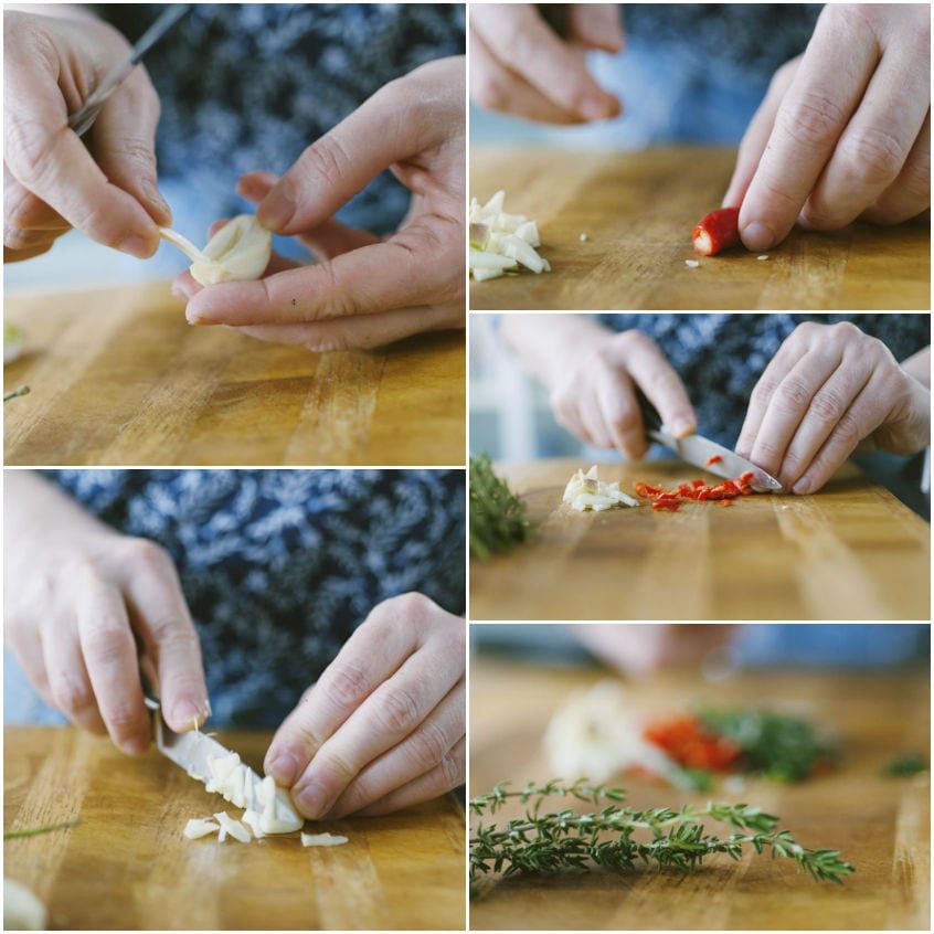 Aglio, peperoncino e erbe aromatiche tritati sul tagliere per la marinatura degli spiedini