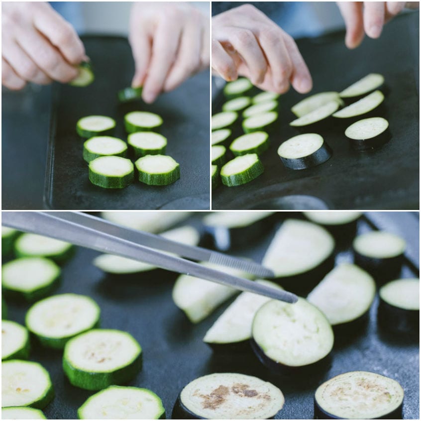 Fette di zucchine e melanzane grigliate disposte sulla piastra, girate con le pinze