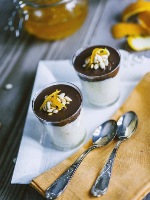 Bicchierini di riso al latte con crema al cioccolato fondente, pinoli tostati e scorza d'arancia candita