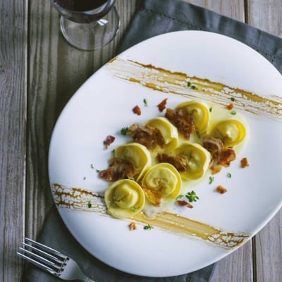Cappellacci ripieni di patate con salsa cremosa, pancetta croccante e erbe fresche