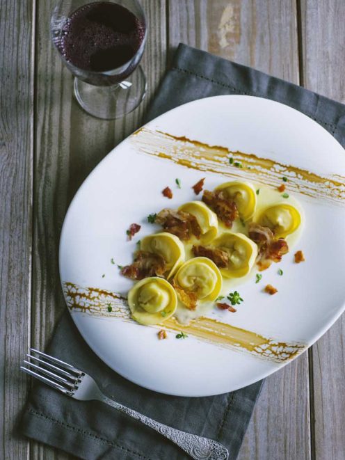 Cappellacci ripieni di patate con salsa cremosa, pancetta croccante e erbe fresche