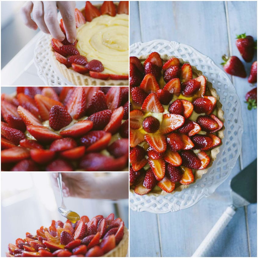 Fragole a fette disposte a cerchi concentrici sulla crema pasticcera della crostata, con una mano che aggiunge le ultime fragole
