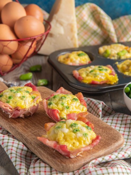 Frittatine nella pancetta con uova, piselli e formaggio, servite su tagliere