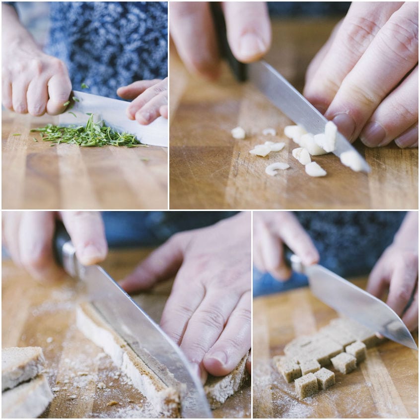 Mani che tritano erbe aromatiche e aglio, poi tagliano la mollica di pane di segale a dadini