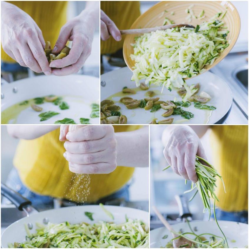 Zucchine grattugiate versate in padella con olive e erbe aromatiche aggiunte a mano