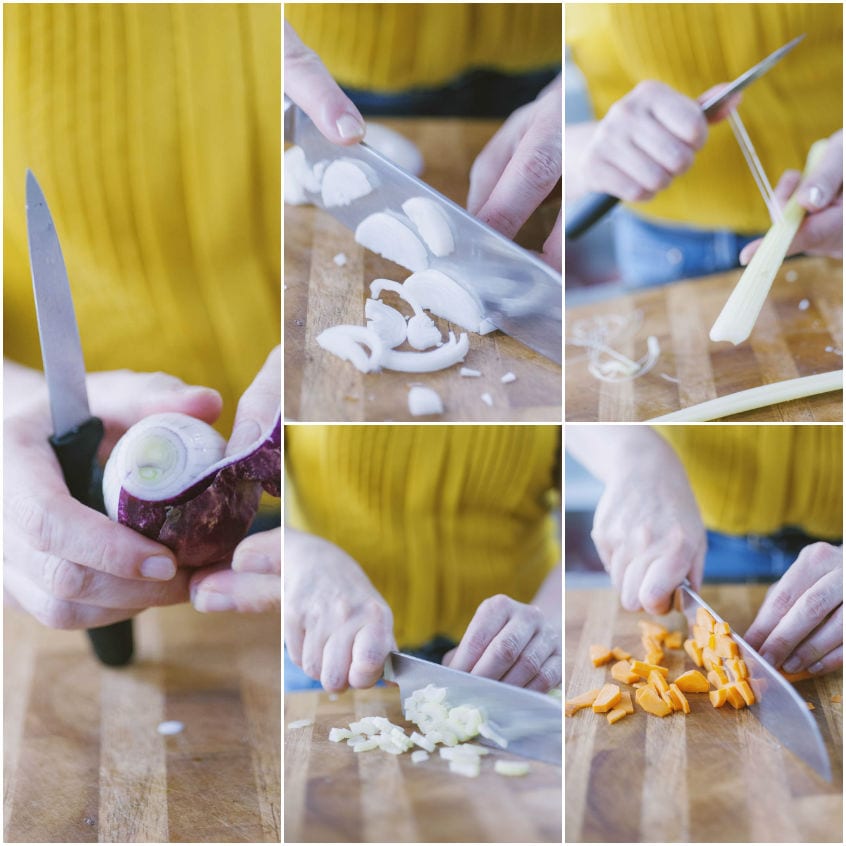 Verdure per il soffritto tagliate a dadini sul tagliere: cipolla rossa, cipollotto, aglio e carota