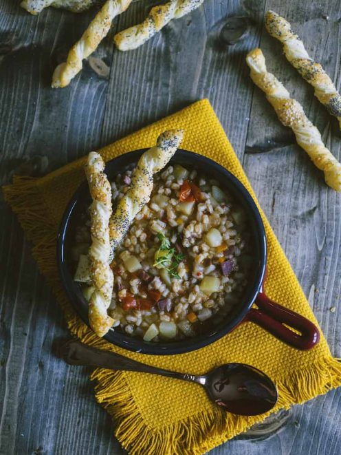 Zuppa di farro con verdure e patate, servita con grissini di sfoglia ai semi