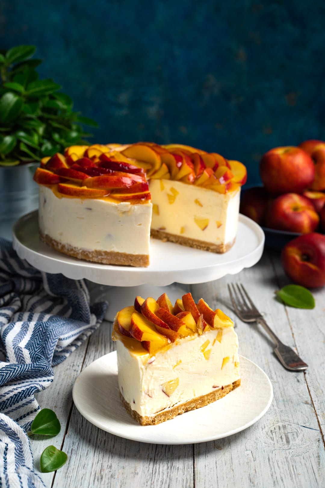 Fetta di cheesecake alle pesche con crema soffice, pezzi di frutta e base di biscotto