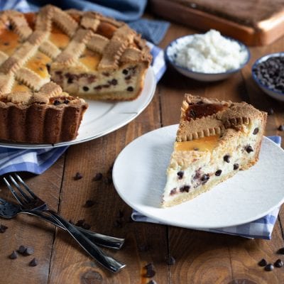 Crostata al mascarpone e gocce di cioccolato con una fetta tagliata che mostra il ripieno cremoso